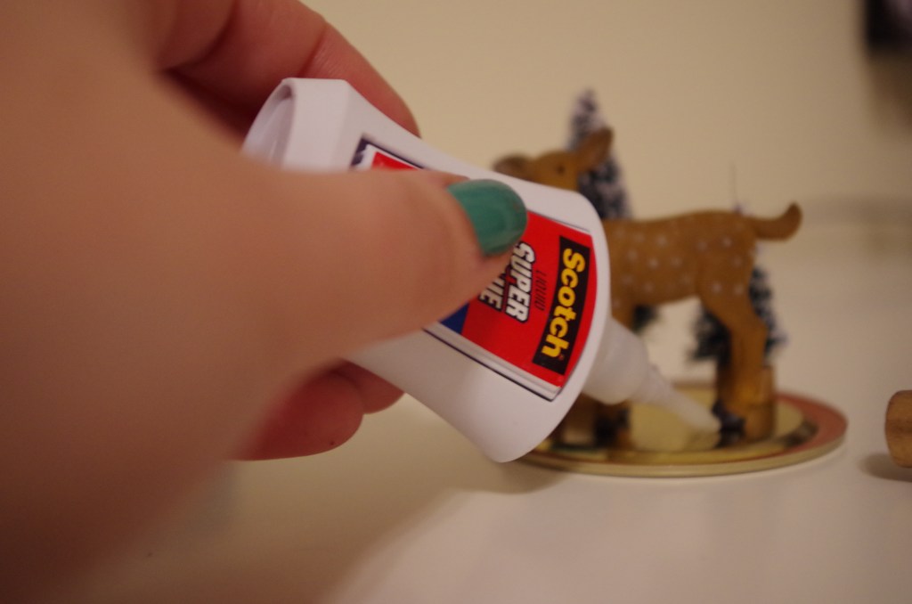 Now that you've created your festive scene and made sure that the Mason jar can handle all that festivity, glue the figurines to the jar lid using the superglue you accidentally left out of the photograph you took of necessary supplies.