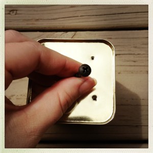 It’s important that your tea tin provide proper drainage for all of the times that you forget that you watered your cactus, like, two hours ago and water it again, so that your cactus doesn’t rot from the inside and then just sort of sadly collapse, like your dream of being a weather girl.  Take a rusty screw you have lying around and a hammer and use them to poke holes in the bottom of the tea tin.*  You can use the tea tin’s lid as a dish to catch any excess water, and you should feel extremely proud of this moment of efficiency. *Actually you probably shouldn’t do this at all, because this might actually be dangerous.  But, then again, if you’ve had a tetanus shot recently, you don’t want to waste it, right? 